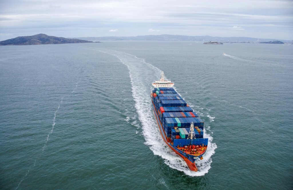 Aerial view of a large container ship sailing through open ocean waters.